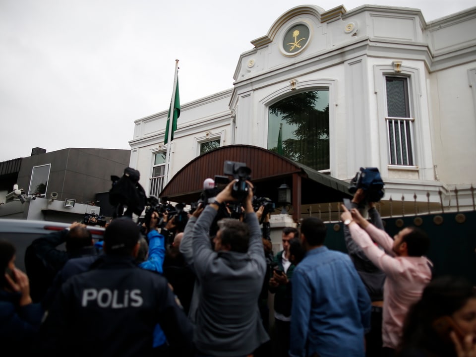 Medienleute umringen Männer vor dem Gebäude der saudischen Botschaft.