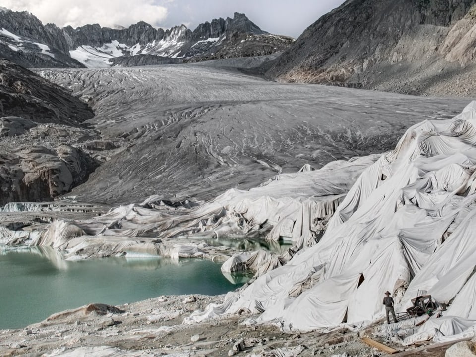 Gletscher mit Planen verhüllt, man sieht wie sich das Eis über die Jahre zurückzieht
