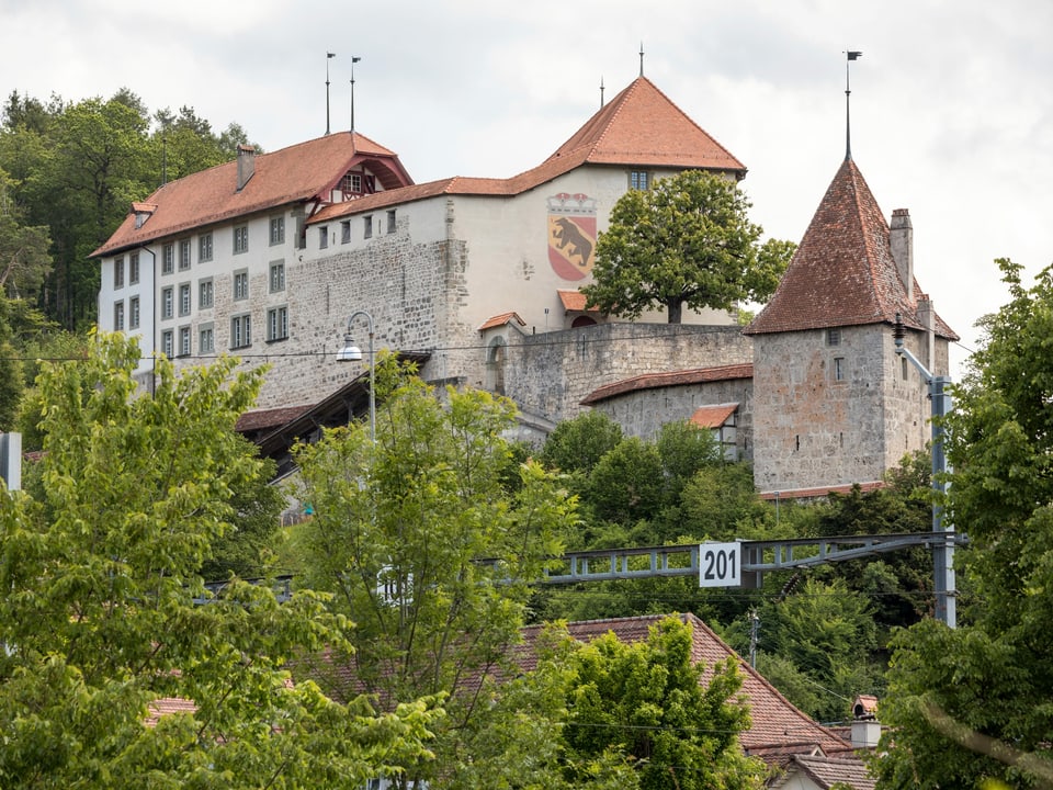 Ein Schloss mit einem grossen Berner Wappen an der Fassade.