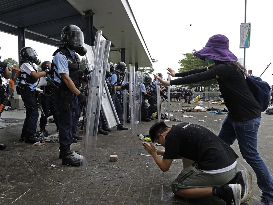 Demonstrant kniet vor Polizei auf dem Boden