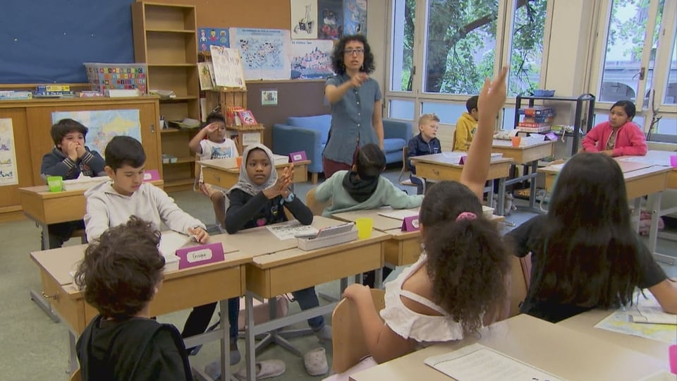 Lehrerin spricht zu Schülern im Klassenzimmer.
