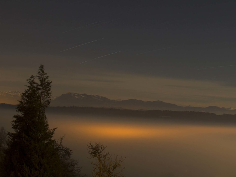 Belichteter Nebel und Berge in der Nacht.