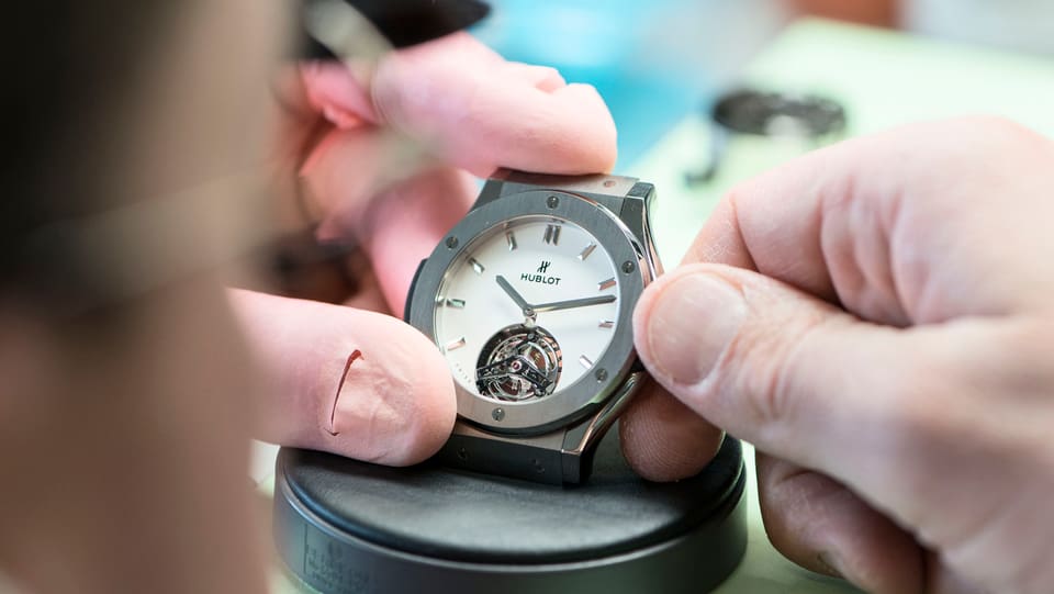 Ein Uhrmacher baut eine Uhr zusammen.