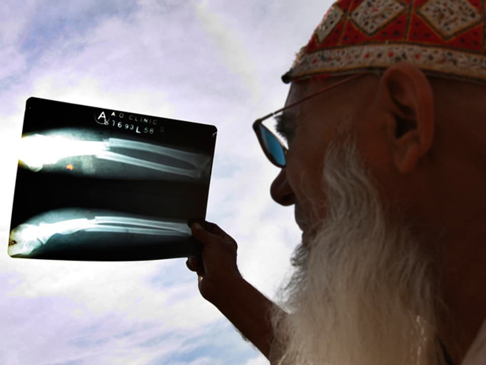 Pakistani betrachtet Sonnenfinsternis durch Röntgenbild.