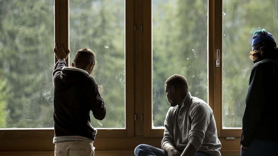 Männer schauen im Bundesasylzentrum Glaubenberg aus dem Fenster.