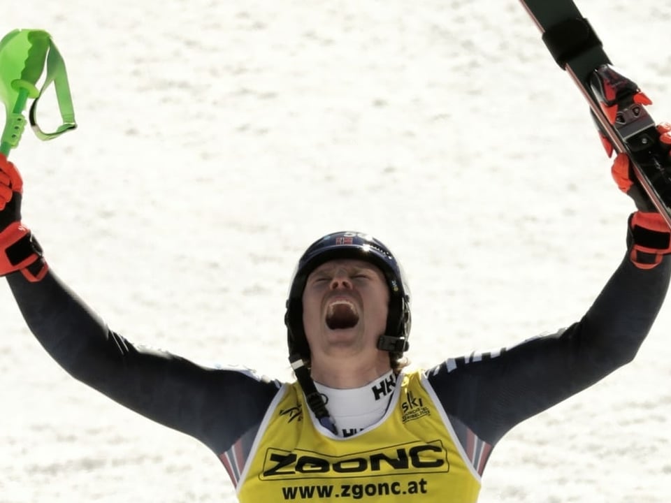 Henrik Kristoffersen reckt seine Ski in die Höhe.