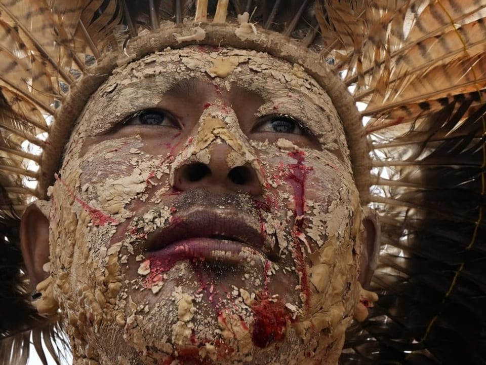 Indigener Mann mit Gesichtsfarbe und Schmuck