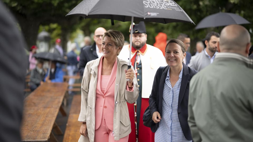 Karin-Keller-Sutter mit Regenschirm und Lächeln im Gesicht
