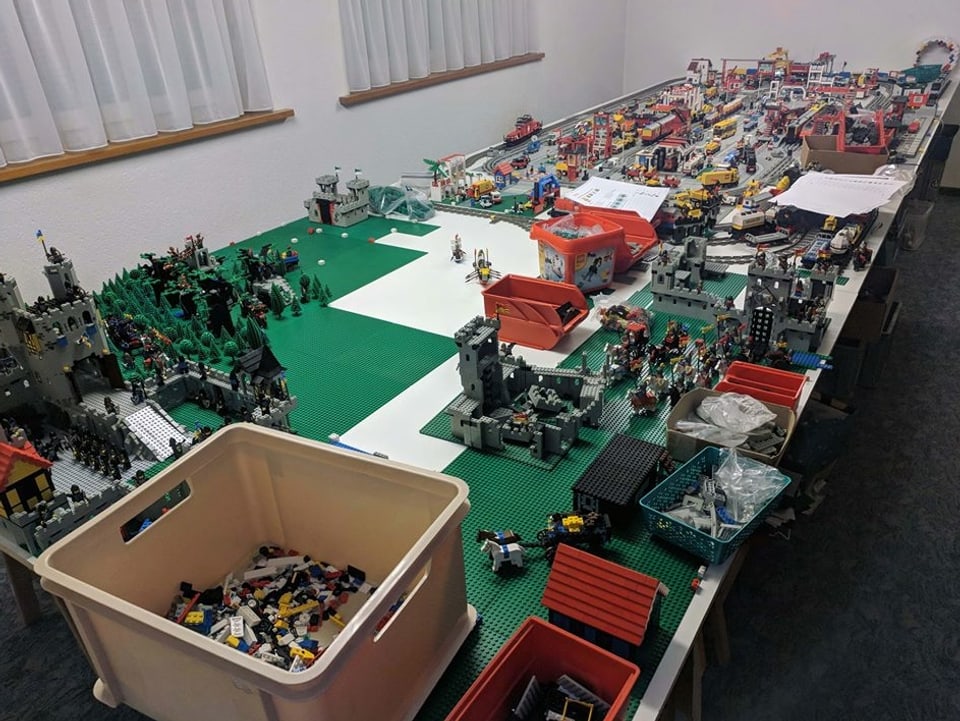Das Bild zeigt einen langen Tisch mit viel Lego darau. 