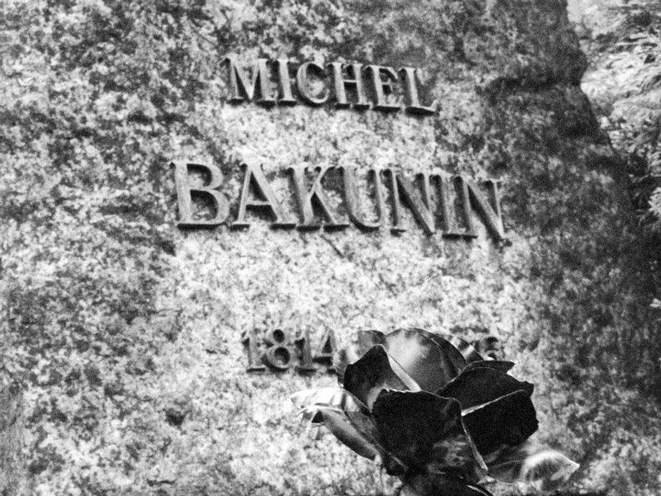 Schriftzug «Michel Bakunin» auf seinem Grabstein in Bern, davor eine Rose, Bild schwarz-weiss.