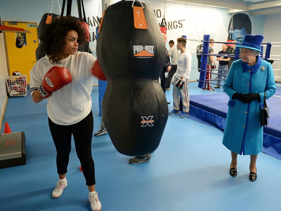 Queen Elizabeth schaut sich eine Frau an, die gerade boxt.