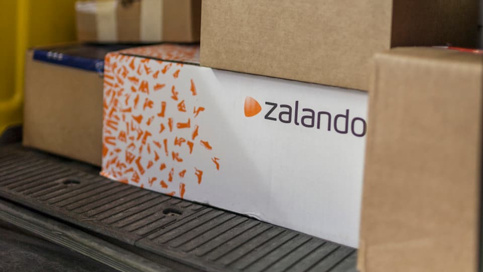 Pakete, u.a. eines von Zalando, im Fonds eines Post-Lieferwagens.