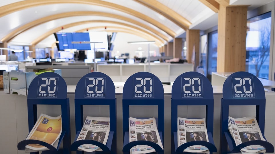 Zeitungständer mit Ausgaben von «20 Minuten» in Redaktionsbüro