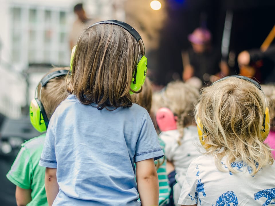 Mehrer Kinder mit Kopfhörer als Ohrenschutz
