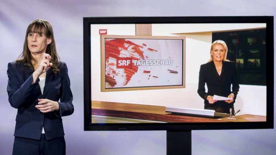 Frau übersetzt TV-Beitrag auf Gebärdensprachen