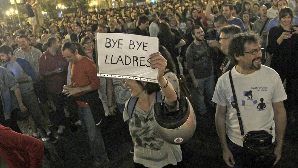 Eine Frau hält ein Plakat mit der Aufschrift «Bye bye Diebe» in die Höhe.