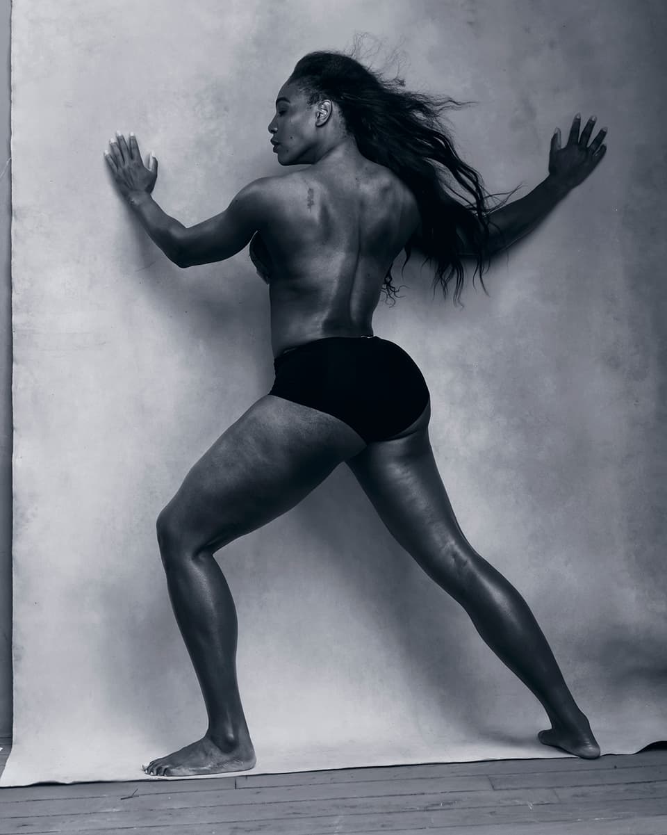 Schwarz-Weiss-Bild von Serena Williams, die in Unterhose mit dem Rücken zur Kamera an einer Wand steht. 