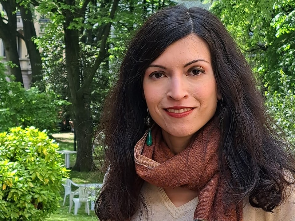 Woman with brown scarf in garden.