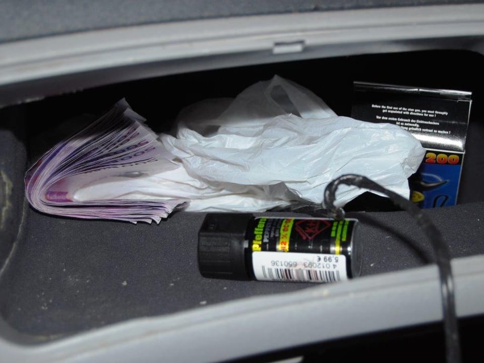 Blick in ein Airbag-Fach: Mehrere 500-Euro-Scheine und ein Pfefferspray sind zu sehen. 