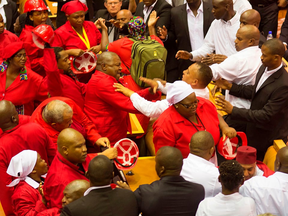Rotgekleidete Parlamentarier bei einer Rangelei im Parlamentssaal