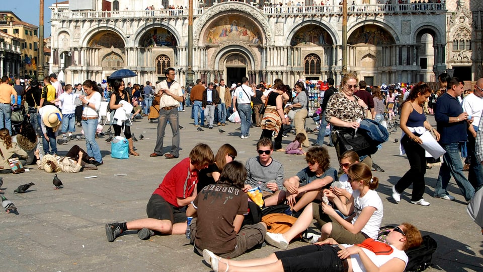 Touristen sitzen auf dem Markusplatz in Venedig
