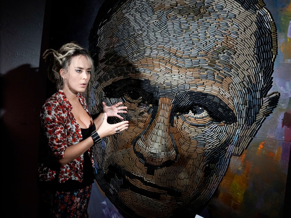 Künstlerin vor Putin-Porträt.