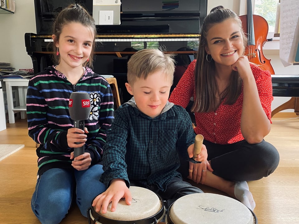 Julia, Matteo und Angela sitzen im Wohnzimmer.