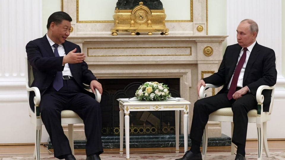 Xi Jinping (links) und Wladimir Putin sitzen auf Stühlen auf einer Art Bühne