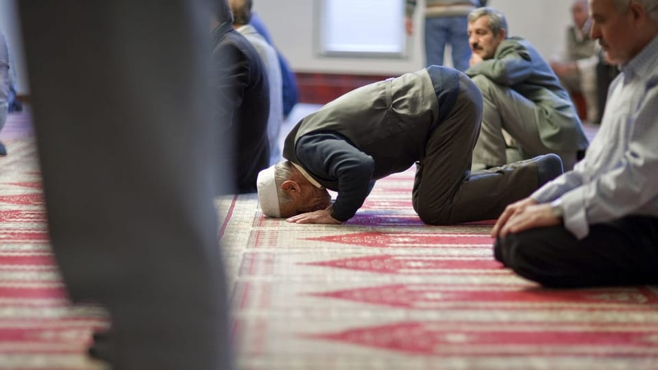 Ein Mann muslimischen Glaubens kniet nieder und betet zu Gott.