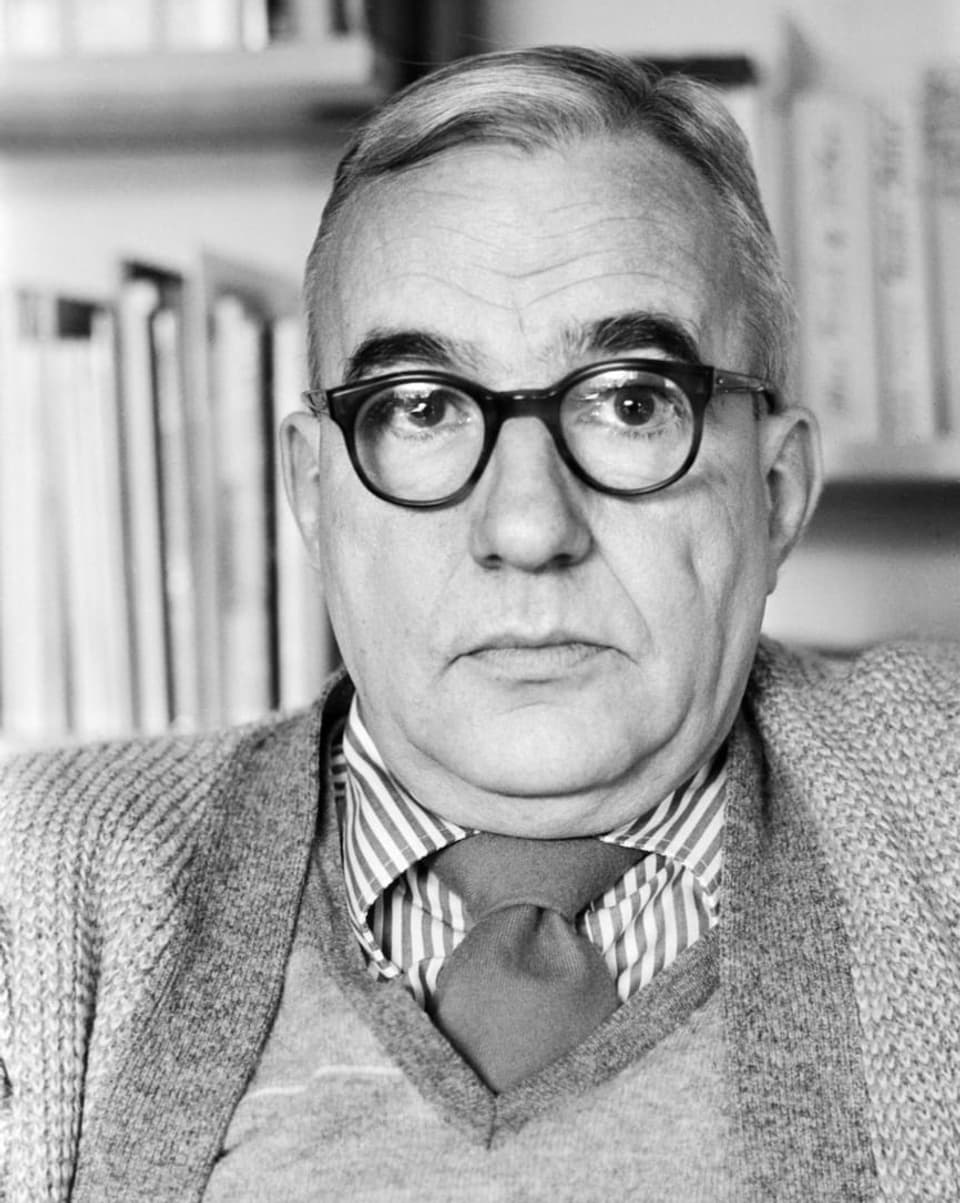 Schwarz-Weiss Bild von einem älteren Herr mit dunkler, dicker Brille