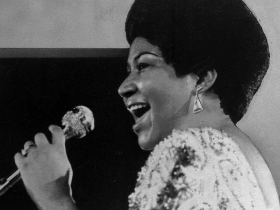 Junge Aretha Frankling hält Mikrofon in der Hand und singt.