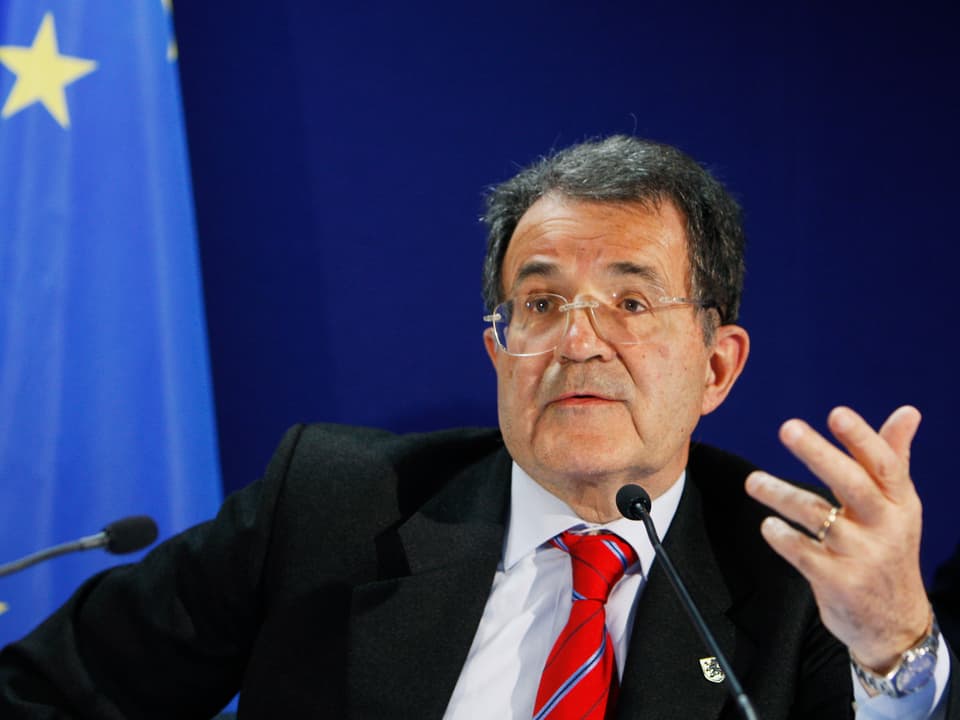 Romano Prodi sitzt hinter zwei Mikrofonen