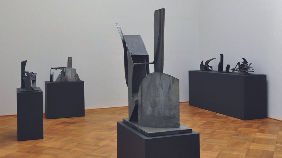 Eisen- und Stahlskultpturen stehen auf Podesten in einem Raum verteilt. 
