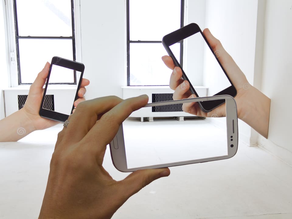 Übergrosse Smartphones ohne Inhalt fungieren als Rahmen in einer Ausstellung.