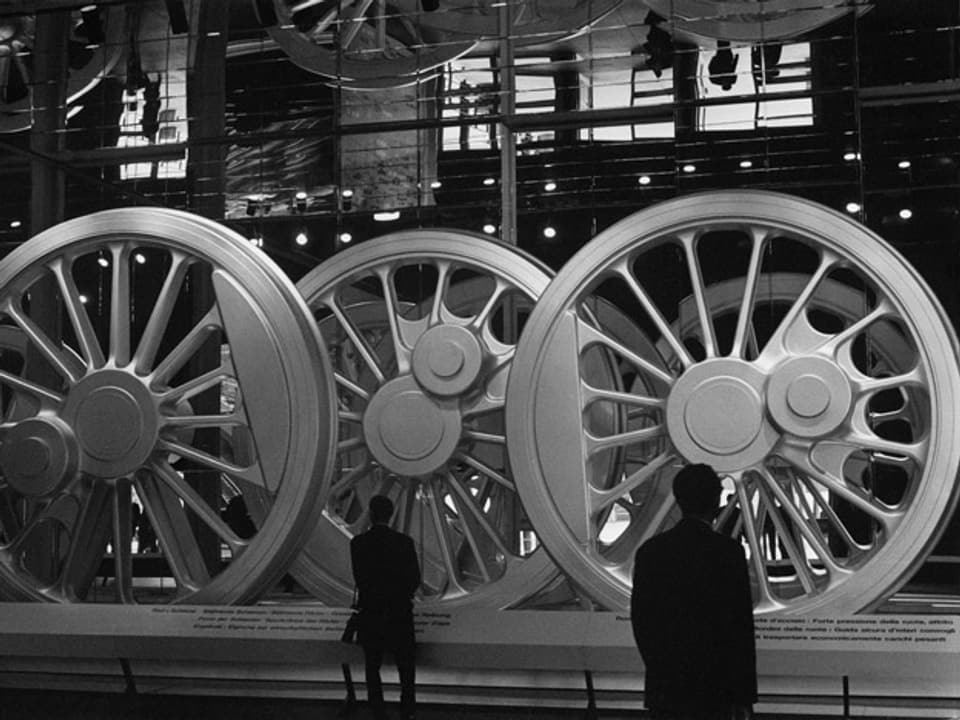 Besucher bewundern an der Expo 64 die ausgestellten Stahlräder für Dampflokomotiven