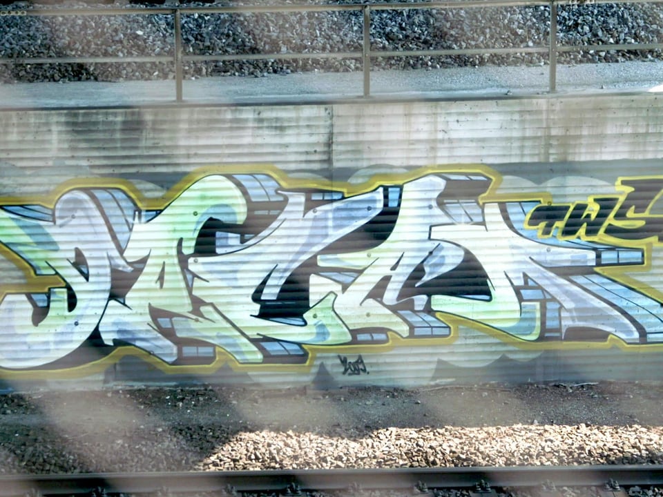 Graffiti-Schriftzug an einem Bahngeleis