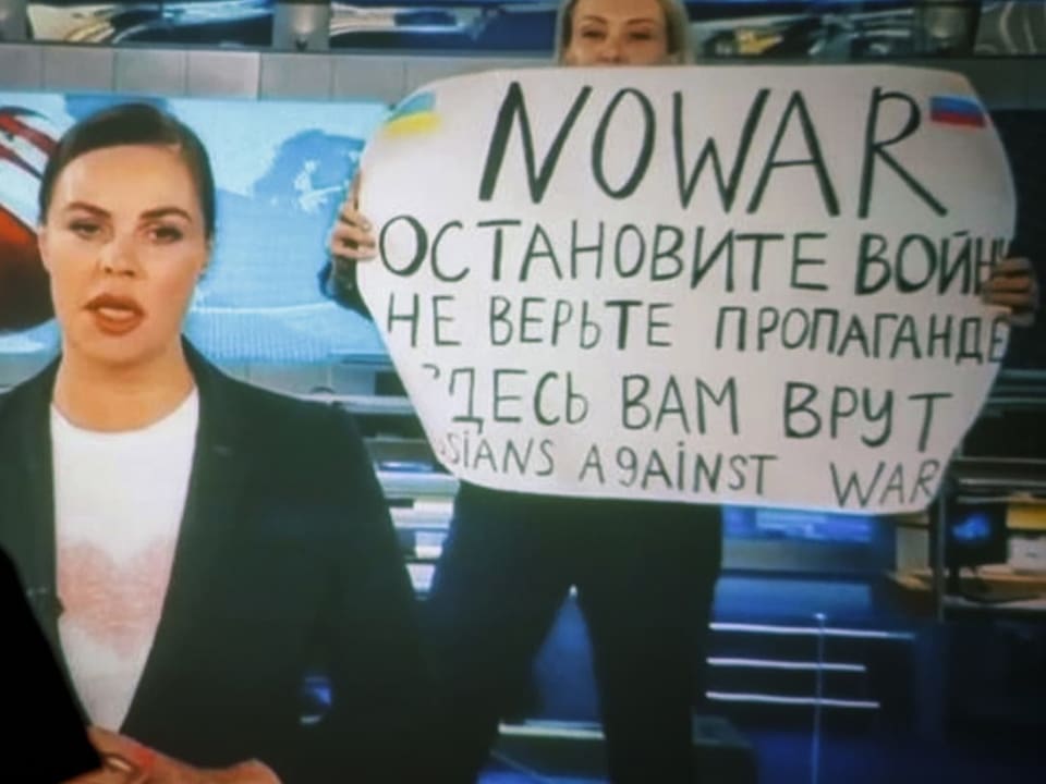 TV-Mitarbeiterin Marina Owsiannikowa hält im Staatssender während der Nachrichtensendung ein Plakat in die Kamera.