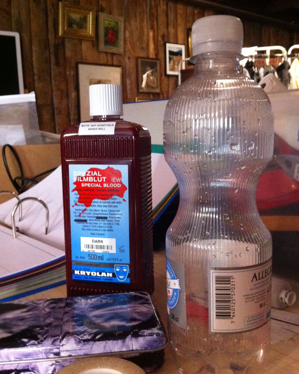 Eine Flasche mit Filmblut und eine Flasche Mineralwasser.