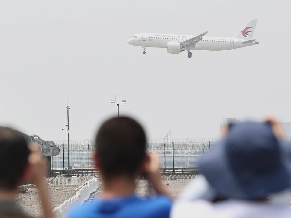 Menschen fotografieren die Ankunft des chinesischen Passagierflugzeugs C919