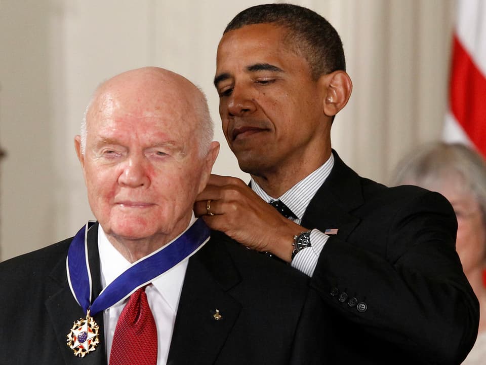 Obama bindet Glenn eine Medaille um