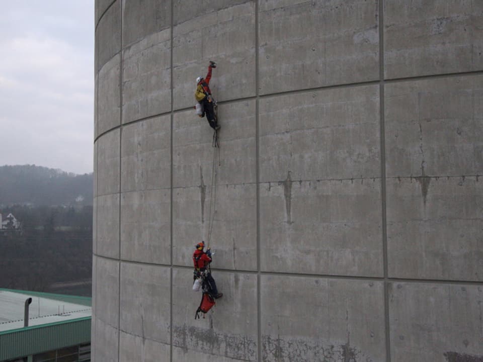 Aktivisten klettern an einem Turm hoch.