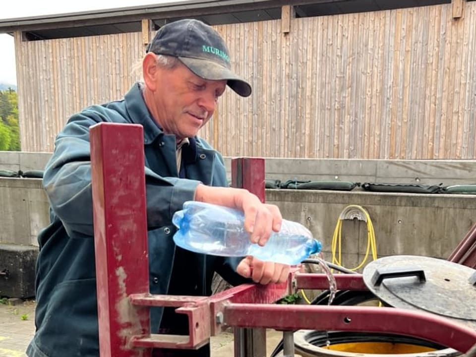 Mann giesst Wasserflasche in Tank.