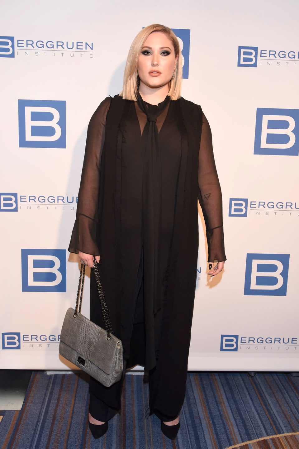 Hayley Hasselhoff posiert mit einer Handtasche für Fotografen. 