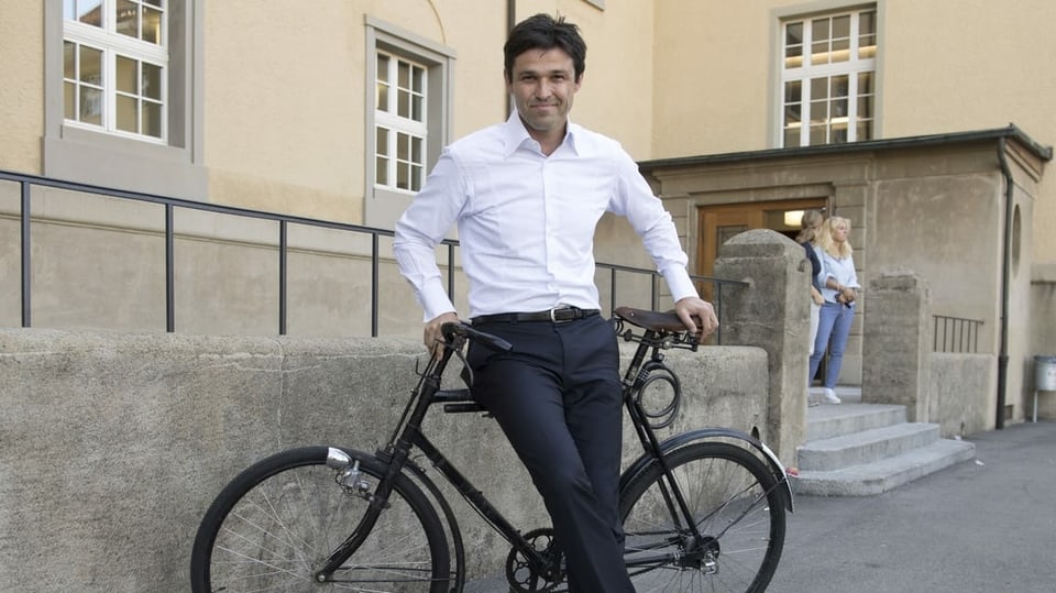 Der SP-Nationalrat und der Präsident von Pro Velo posiert auf einem schwarzen rennvelo.