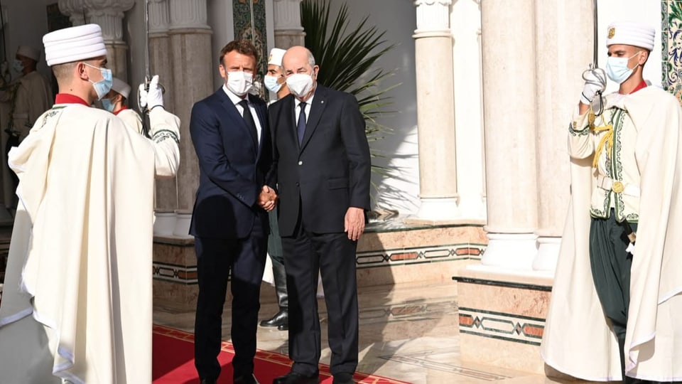Der französische Präsident Emmanuel Macron schüttelt dem algerischen Präsidenten Abdelmadjid Tebboune die Hand