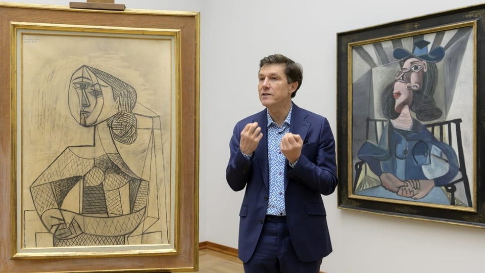 Mann zwischen zwei Werken von Picasso.