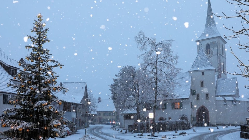 Kirche und Weihnachtsbaum im Schneegestöber