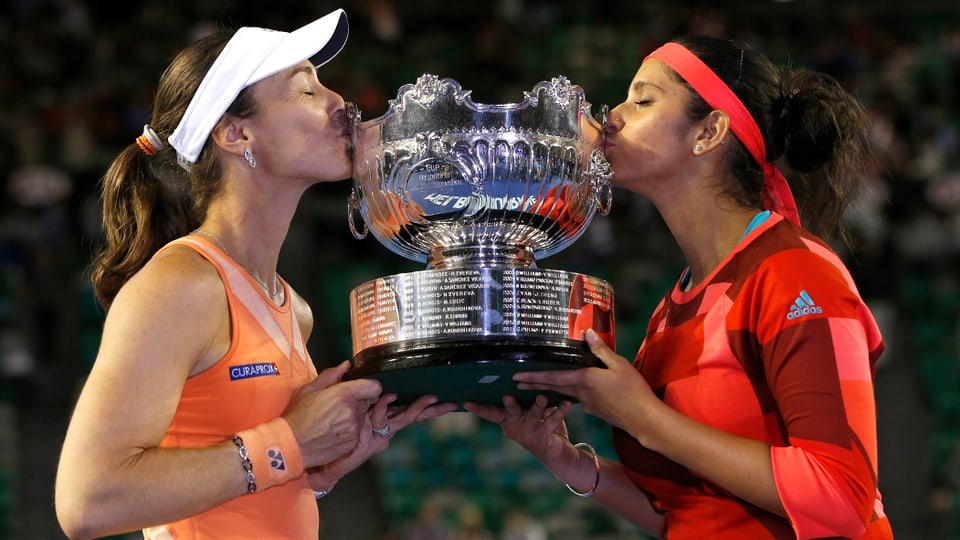 Martina Hingis und Sania Mirza küssen einen Pokal.