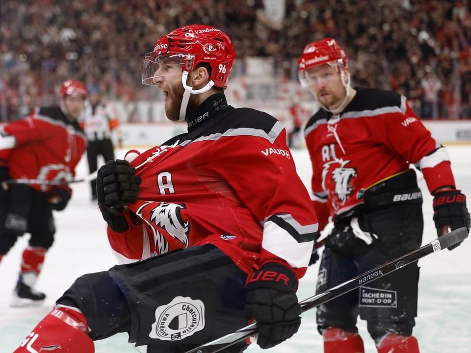 Eishockeyspieler in roter Ausrüstung jubelt auf dem Eis