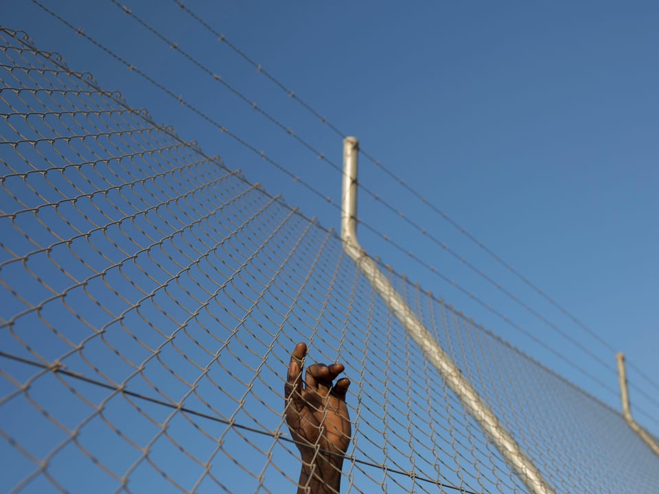 Migrant klettert Zaun an Enklave Ceute hoch. 